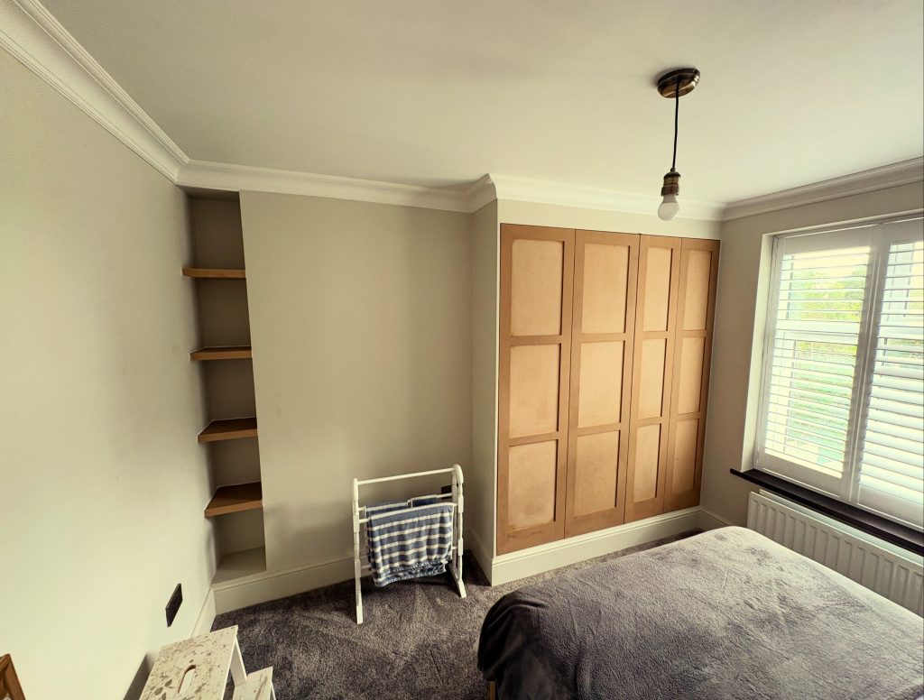 Image of a built in wardrobe with shaker style doors. The doors have three panels on each, with a total of four doors.