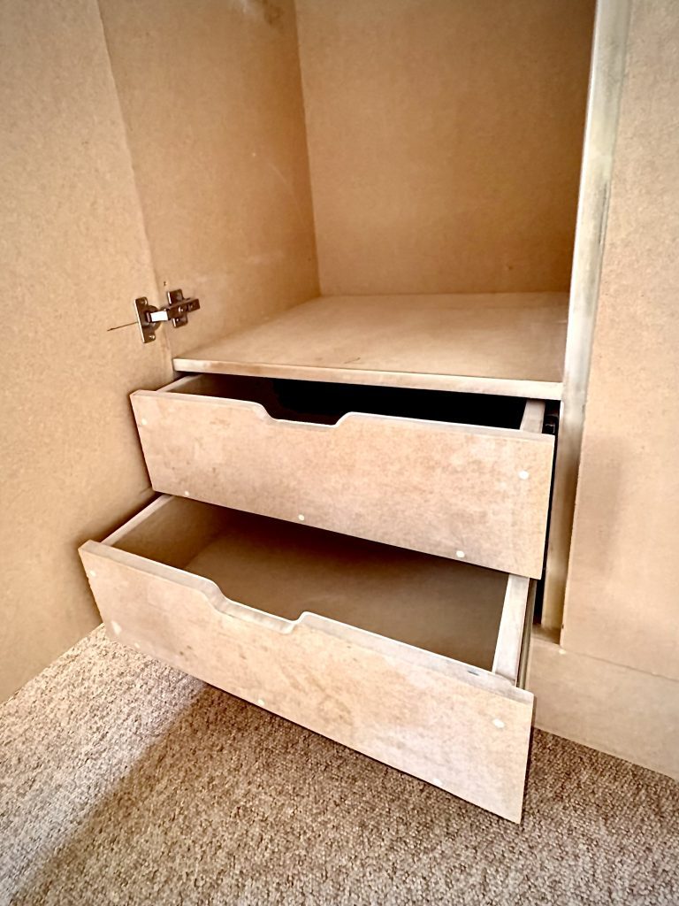 An image of two drawers that have been recessed into a cupboard. The drawers are both pulled out a way. They are made out of MDF wood